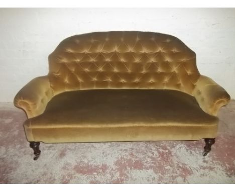 AN EDWARDIAN TWO SEATER UPHOLSTERED BUTTON BACK SOFA