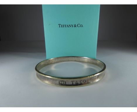 Tiffany & Co silver bangle together with a pair of silver heart shaped stud earrings marked Tiffany and a pair of Hot Diamond