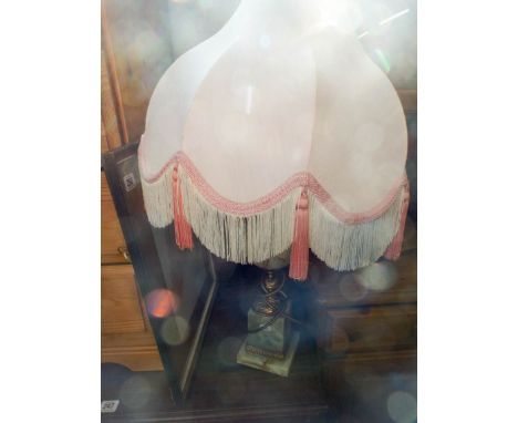 An onyx table lamp with fringed shade and a framed sepia toned print of a girl framed and glazed 