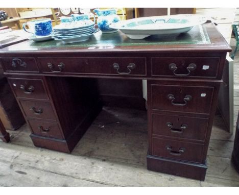 A reproduction mahogany writing desk with inset green leather top 