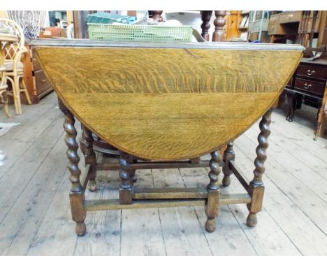 An oak drop leaf gate legged dining table on barley twist legs 