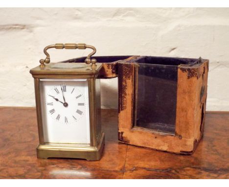 A gilt brass carriage clock in a leather travelling case with a key 