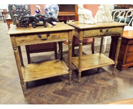A pair of good quality distressed oak two tier lamp or side tables each fitted one drawer 
