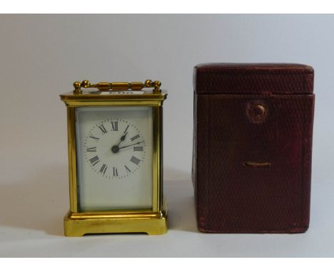  French gilt brass carriage clock with a leather travelling case, 15cm tall with the handle up 