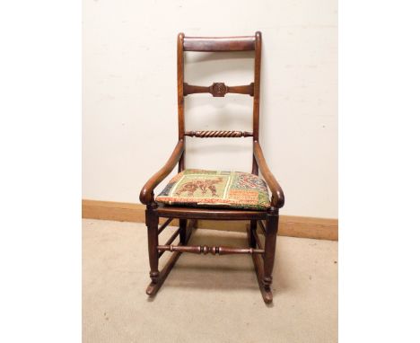 A regency mahogany rocking elbow chair with rope twist back and wood panel seat with cushion 