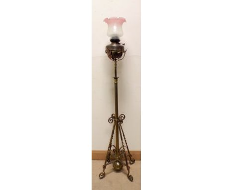 A Victorian adjustable brass standard lamp with oil lamp top and glass shade 