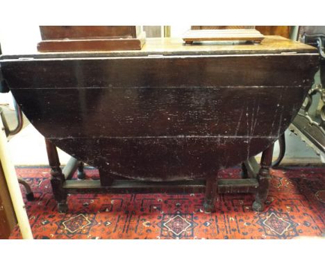 An antique oval oak gate legged dining table on turned legs, 3'6 wide