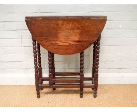 A small oval oak gate legged table on bobbin turned legs, 2' wide