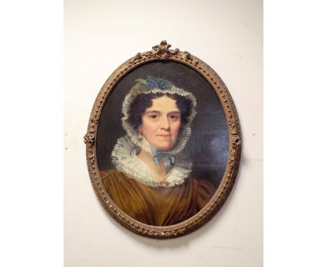 An earth 19th Century oil on canvas portrait of a Regency lady wearing a lacy bonnet 