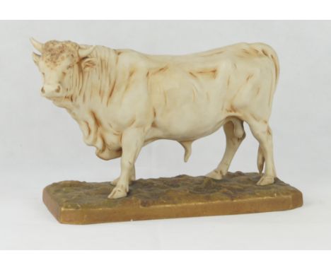 A Royal Dux model of a bullRaised on naturalistic plinth base, embossed triangle mark to base, height 19.5cm, length 28cm    