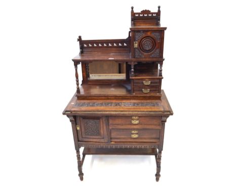 A carved oak writing cabinet, circa 1900The superstructure featuring carved and pierced tiered rails, carved cabinet door, mi