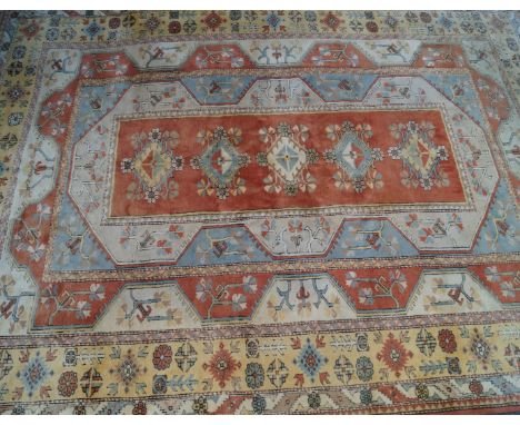 A large Turkish rug on a mainly beige ground 20th CenturyThe central panel with extensive geometric decoration with matching 