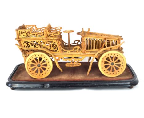 A 19th Century wooden model of a carPossibly by a prisoner of war, inset within glass dome, height including dome 34cm, width