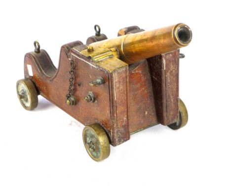 A brass barrelled model cannon, late 19th/early 20th Century24.5cm long barrel mounted on a wooden carriage with brass trunni