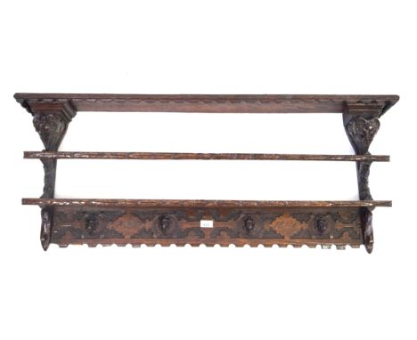 An antique carved oak plate rack in the Flemish tasteThe shaped canopy and fixed shelf above decorative frieze carved 'ANNO 1