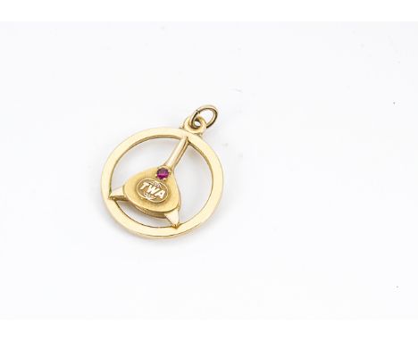 A yellow metal TWA service pendant, set with synthetic ruby above the TWA logo within circular mount, 2.8cm diameter 