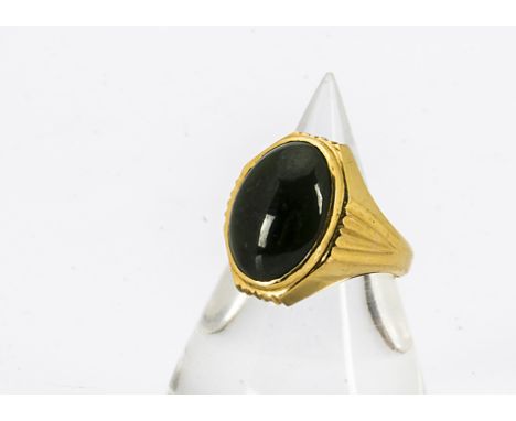 A continental yellow metal and nephrite signet ring, the cabochon oval stone in an art deco style step setting, all in yellow