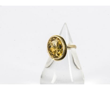 A 9ct gold oval mixed cut citrine cocktail ring, in rubbed over setting, with pierced shoulders, hallmarked to shank, ring si