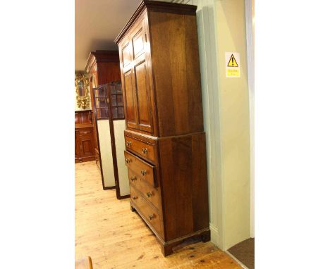 Georgian oak and mahogany linen press having two inlaid panel doors above a base of four long drawers on shaped bracket feet,