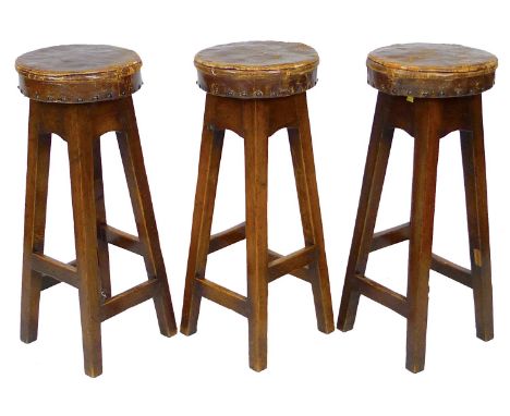 Three vintage oak bar stools, with leather upholstered seats, 30 by 30 by 76cm high. (3) 