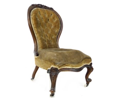 A Victorian button back nursing chair, with walnut carved top-rail, upholstered in olive velvet, 75 by 60 by 97cm high. 
