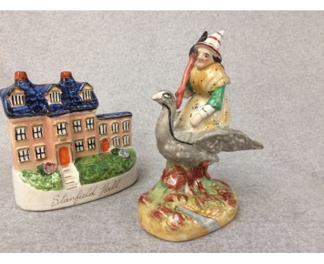 Staffordshire figure of a clown riding a goose and a flat back figure of a house 