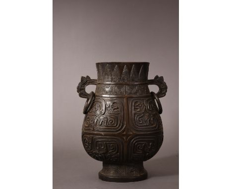 C17th/18th Chinese bronze hu vase, flanked by a pair of chilong handles suspending loose rings, cast with taotie masks below 