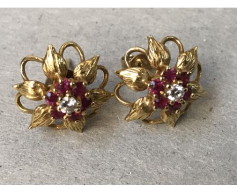 A pair of diamond and ruby, 18 carat gold, cluster ear studs, the seven stone cluster enclosed by leaf motifs, 3.3g gross