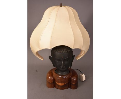 Oriental bronze Buddha head lamp, mounted on wooden stand, fitted for electricity, 58cm high.    Please check condition befor