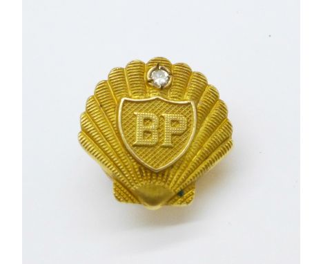 A hallmarked 9ct gold BP button hole badge set with a diamond, 4.6g