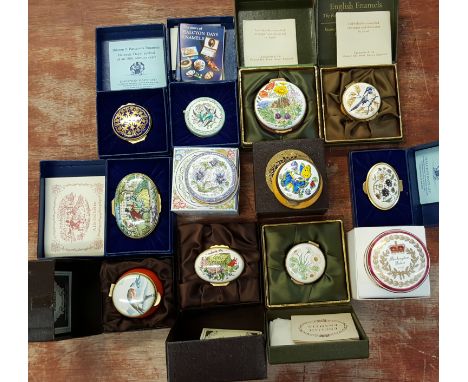 A leather suitcase containing twelve china and enamel pill boxes, one with integral clock, all boxed