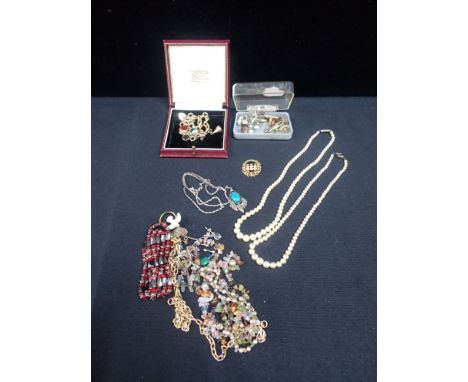A 9CT GOLD CIRCULAR LINK CHARM BRACELET with heart-shaped padlock clasp and hung with seven charms contained in a red leather