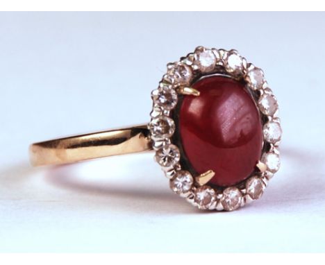 centred with  an oval ruby surrounded by 14 round-cut diamonds