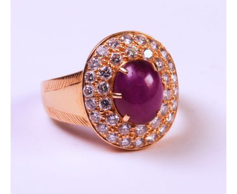 centred with an oval ruby star sapphire surrounded by two rows of round brilliant-cut diamonds