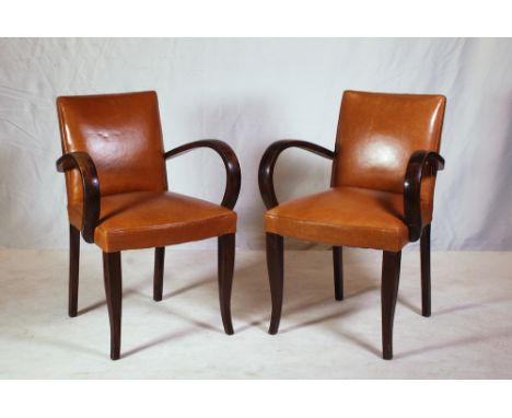 each with cognac leather back and seat, curved arms on outswept legs