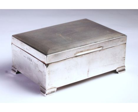 the plain rectangular body, the hinged cover with engine-turned decoration centred with a vacant cartouche, raised on four br