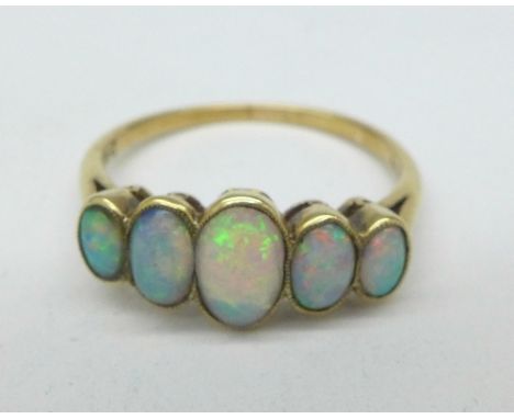 A yellow metal and five opal ring, 2.8g, T, hallmark worn, one stone replaced