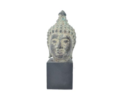 An early 20th century bronze Thai Buddha head on wooden plinth base. The head with pointed beaded headdress. The head measuri