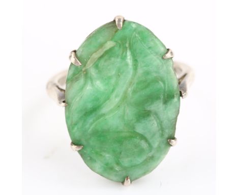 A Chinese silver and carved jade oval panel ring, setting height 20.8mm, size J, 2.8gNo damage or repairs, slight wear to hig