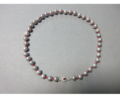 A ruby, diamond and cultured grey pearl necklace, composed of uniform 9mm dove grey pearls alternating with small faceted rub