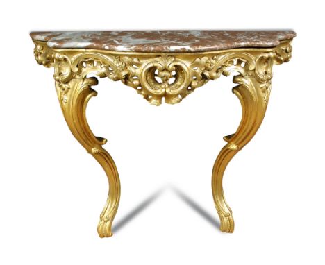 A carved giltwood console table - 19th century, of serpentine outline, the pink grained marble to a leaf and scroll carved ba
