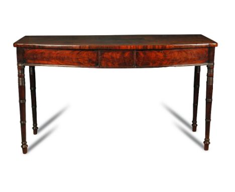 A Regency mahogany bow front serving table, with tablet moulded frieze, ribbed corner panels, on turned column legs 87 x 153 