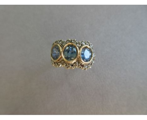 A light blue sapphire and diamond triple cluster ring, the oval cut light green-blue stones, one a doublet, in raised collets