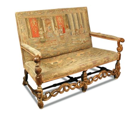 A Carolean revival carved walnut framed settee - late 19th century, upholstered with tapestry panels, with open arms and carv