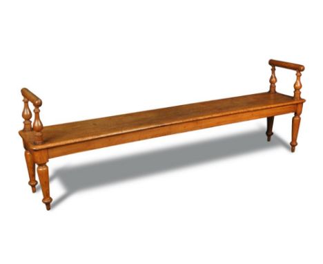 A Victorian oak hall bench - late 19th century, with raised end rails and cushion moulded arm rests, on turned legs 42.50 x 2