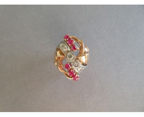 A diamond and synthetic ruby dress ring, collet set to the centre with a round brilliant cut diamond in a diagonal ribbon set