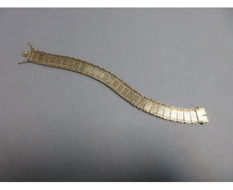 An articulated plaque bracelet with greek key pattern, of yellow precious metal stamped '9ct' and composed of rectangular pla