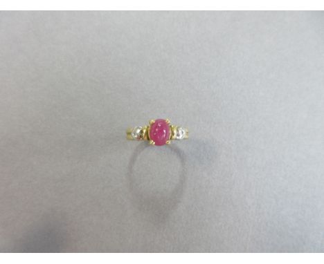 A cabochon ruby ring with diamond highlights, the oval cabochon ruby four claw set between bars and hearts to a reeded shank,