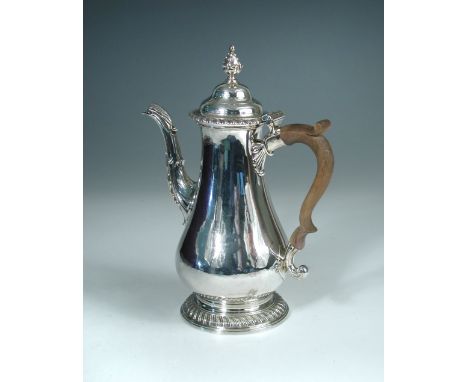A large George III silver coffee pot, maker's mark indistinct, London 1765, of plain baluster form with gadrooned foot and ri