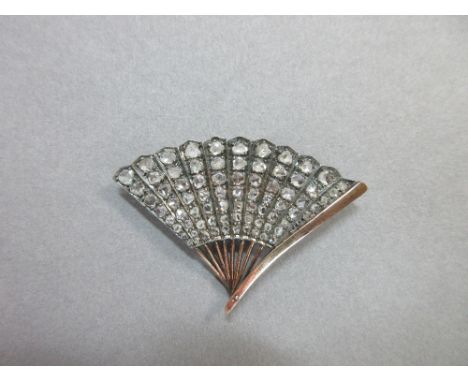 A vintage diamond fan brooch, the eleven leaves set with graduated lines of rose cut diamonds to a polished front guard and r